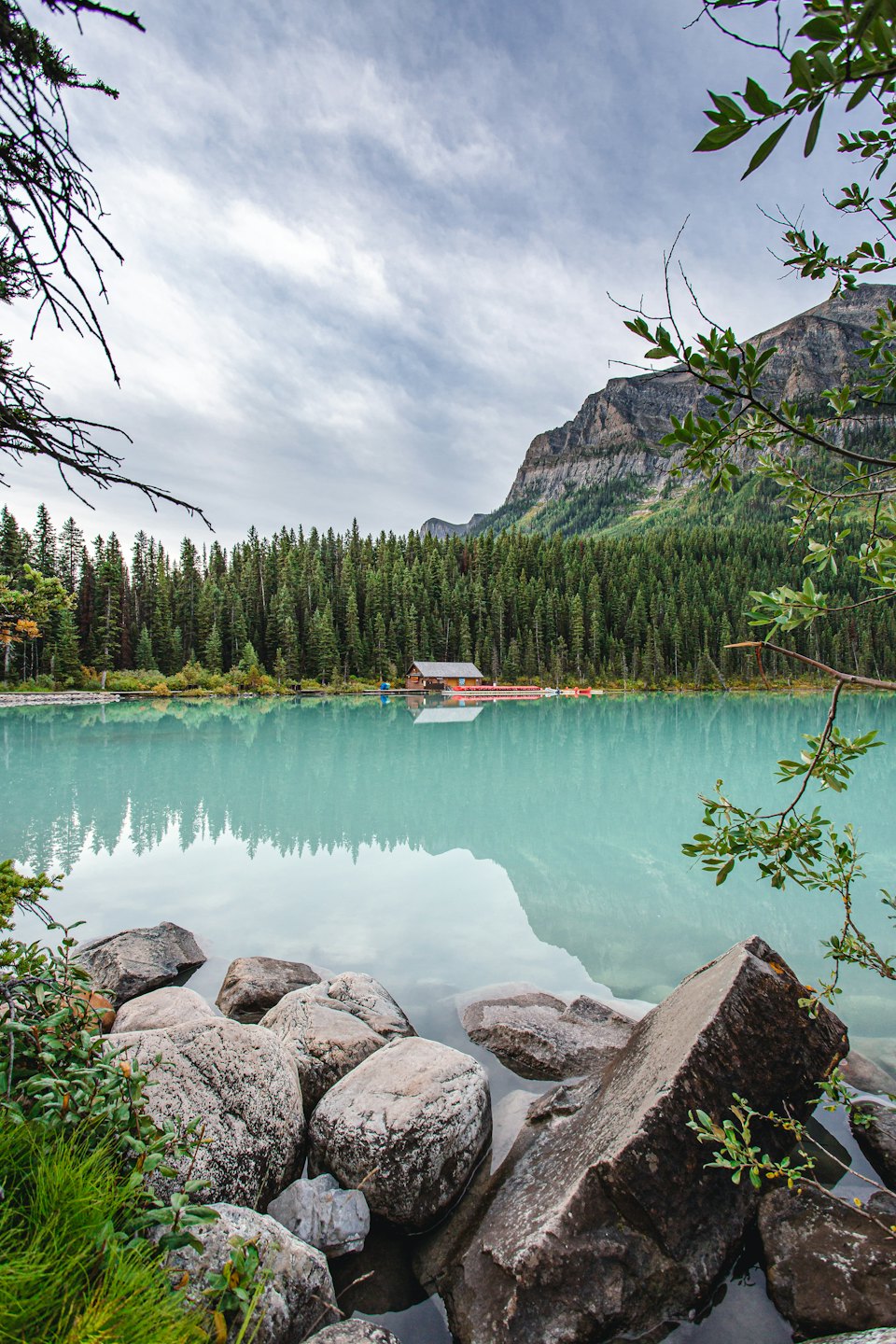 Wooden boathouse sits on the shore of a glacial lake.